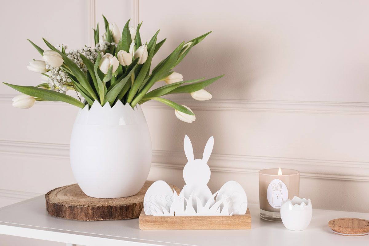 weiße Porzellan-Vase in Eiform mit weißen Tulpen - kleiner Porzellan-Kerzenhalter in Ei-Form - Osterlandschaft auf Holz