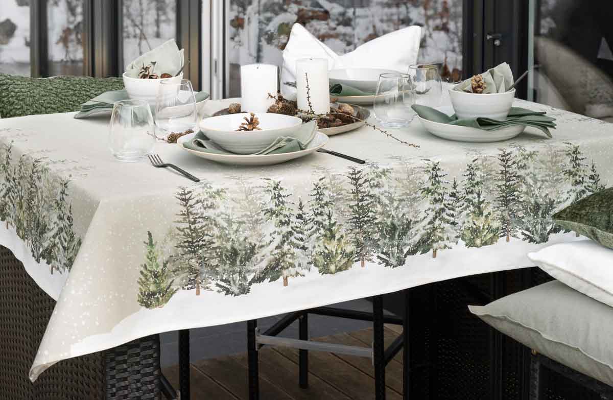 weihnachtlich gedeckter Tisch, Tischläufer mit Tannendekor, Geschirr, Gläser, weißes Porzellan