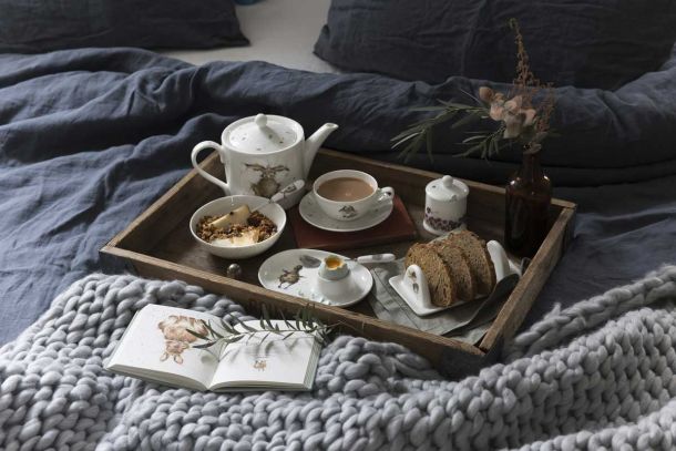 Tablett mit Frühstücksgeschirr im Bett