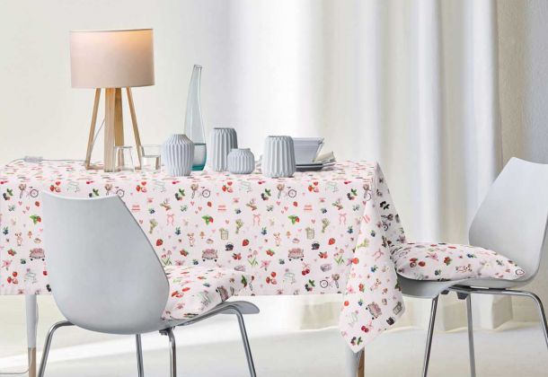 gedeckter Tisch, Tischdecke und Kissen mit buntem Frühlingsdekor