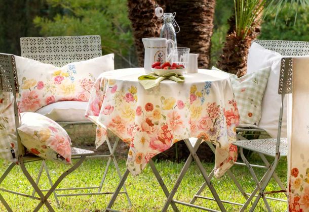 Gartentisch mit Kissen und Decke mit Frühlingsdekor