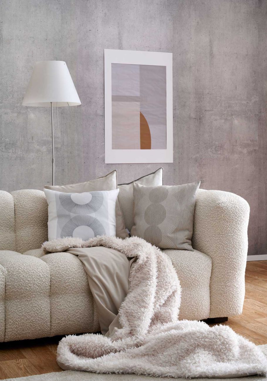 Sofa in Beige mit Kissen und Decke in Felloptik