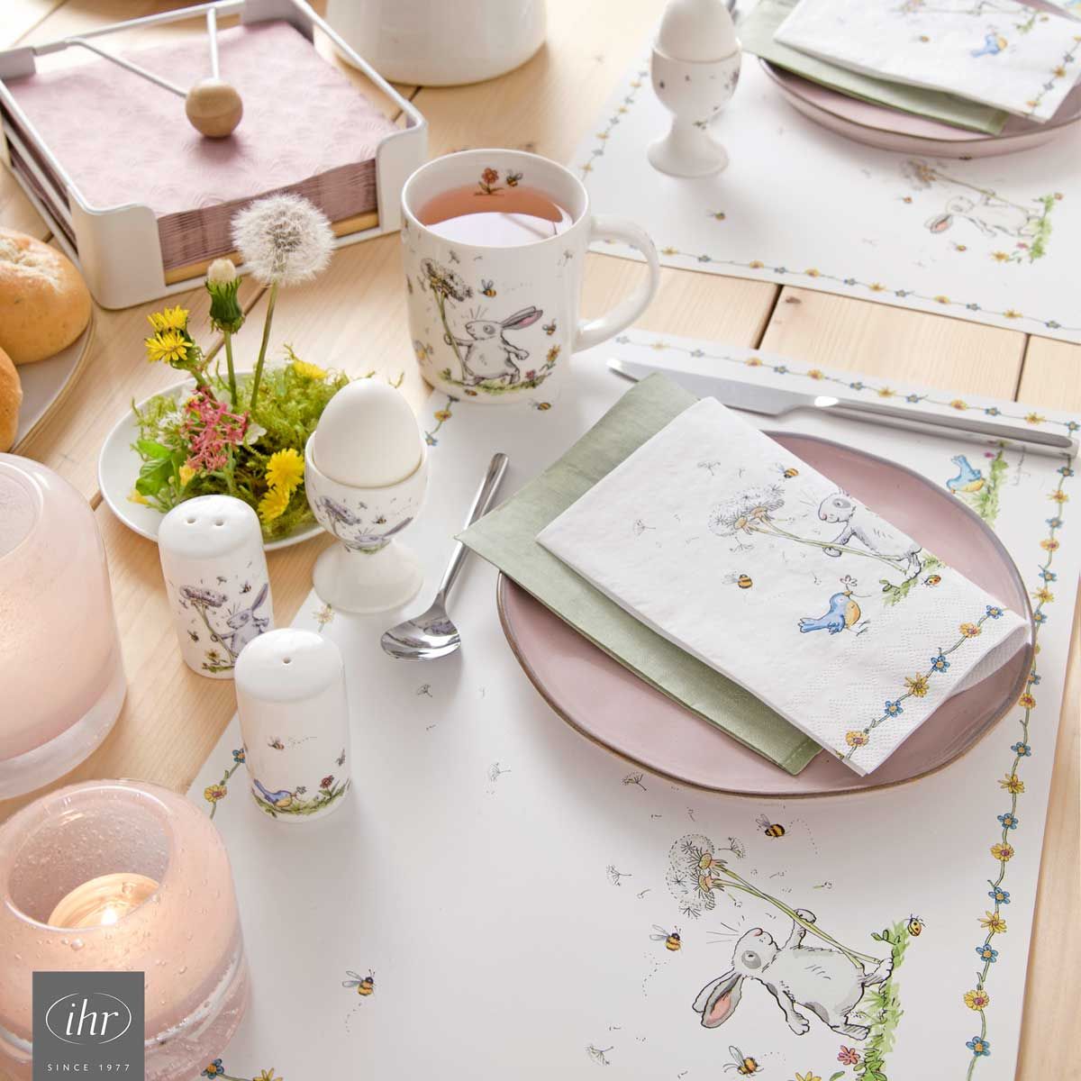 gedeckter Ostertisch mit Servietten, Tasse, Eierbecher, Salz- und Pfeffersteuer im gleichen Osterdekor