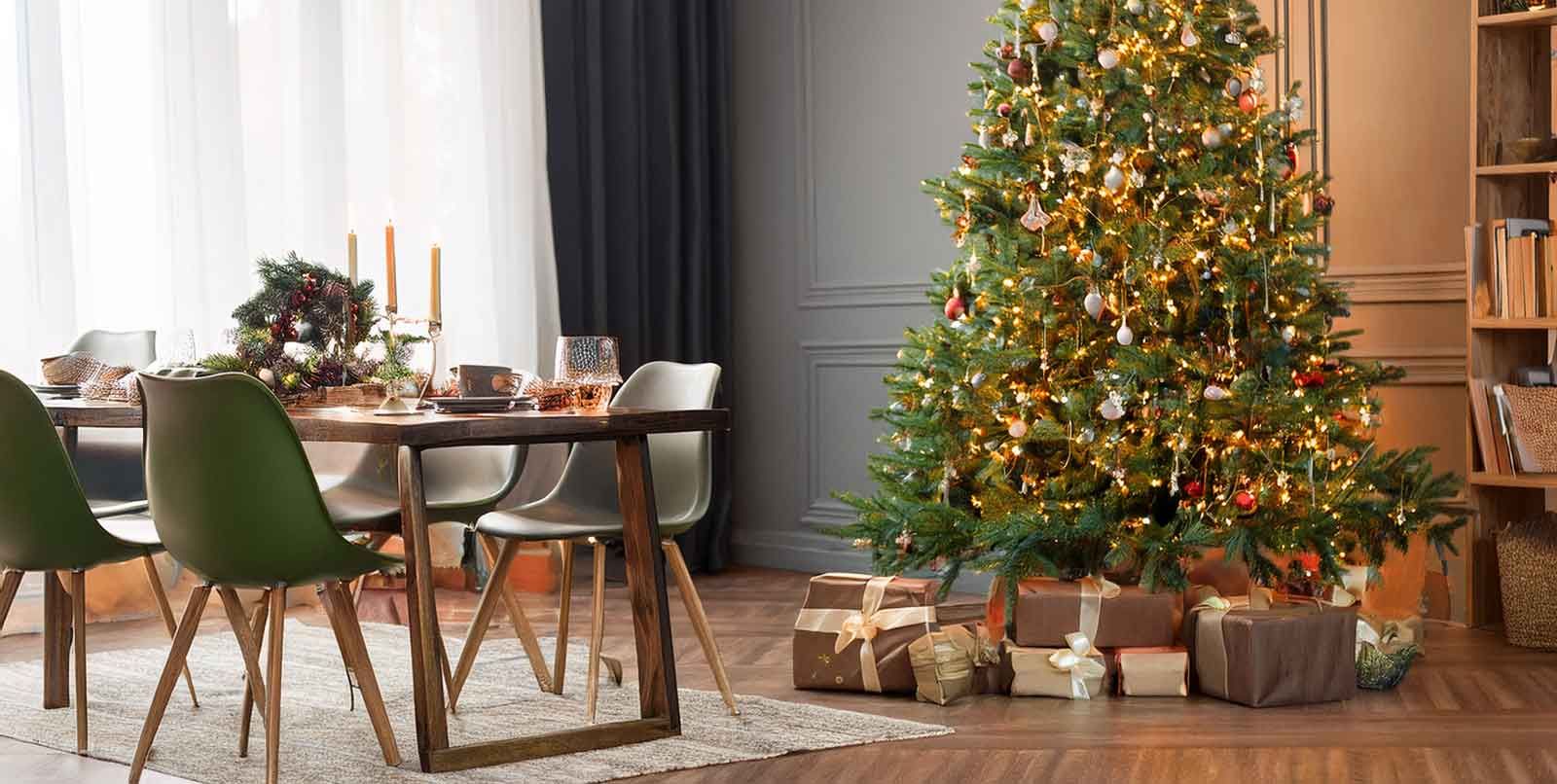  Weihnachtszimmer mit Tannenbaum, gedecktem Tisch und Geschenkepäckchen